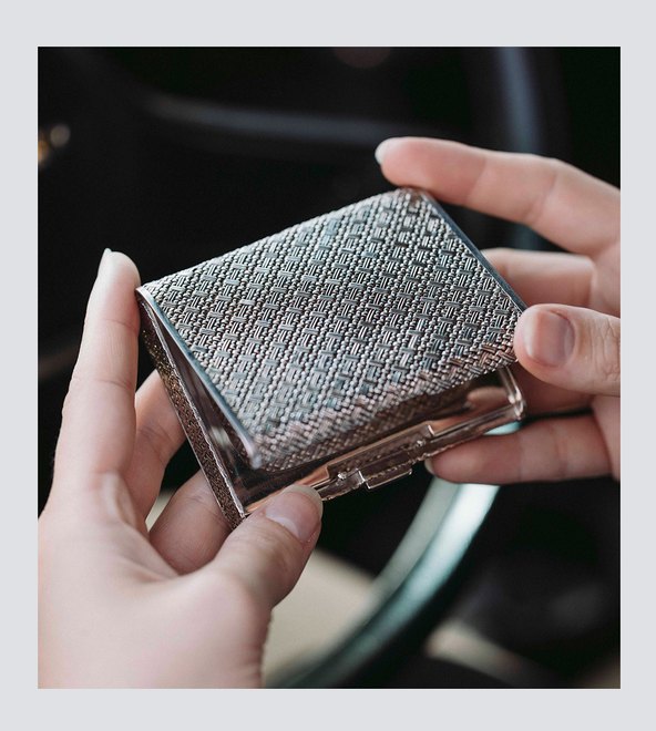 A sterling silver compact held in the hand