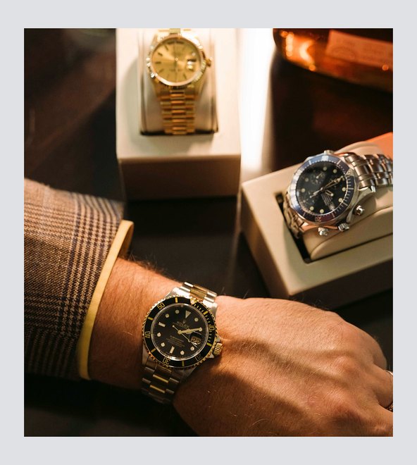 A gold watch and a diver&rsquo;s watch being valued