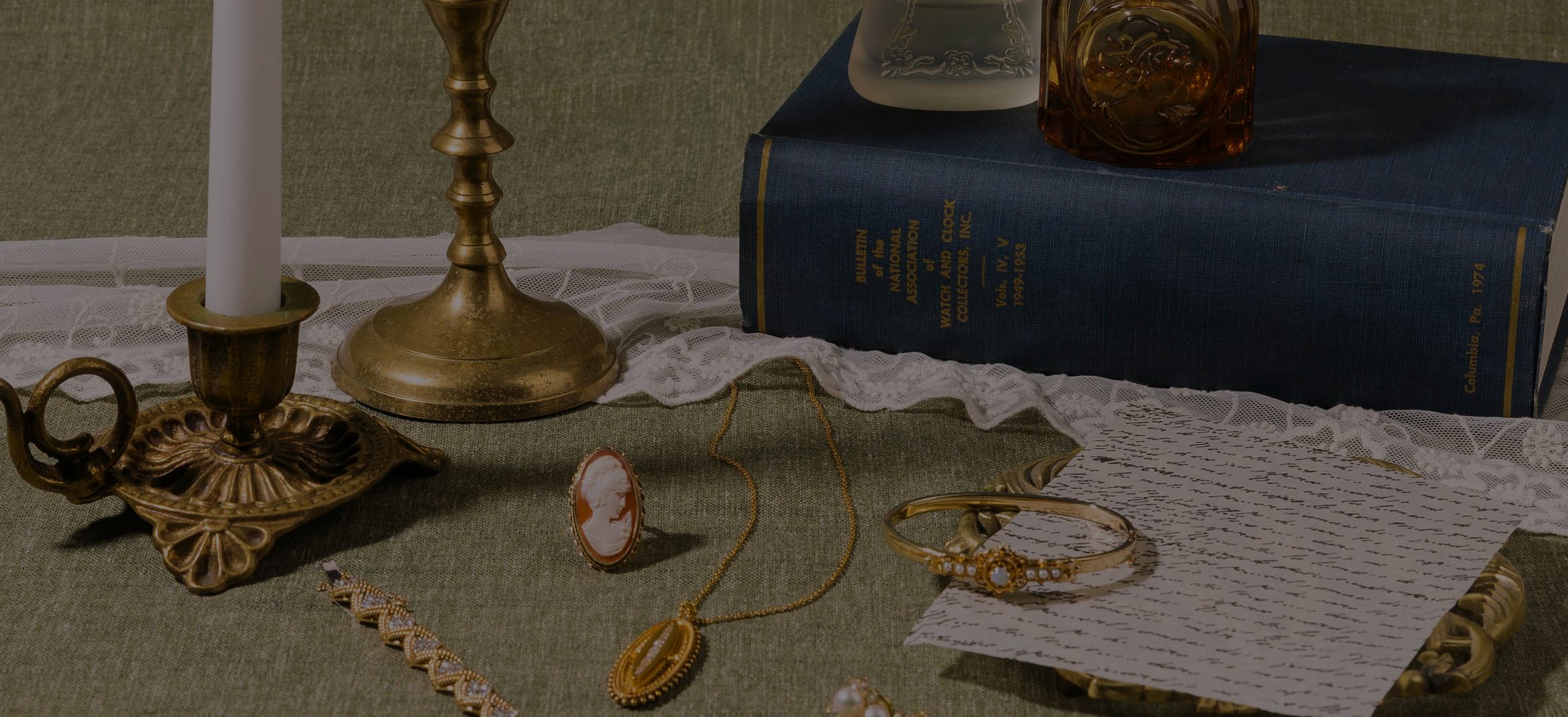 Estate jewelry styled with brass candlesticks and antique books