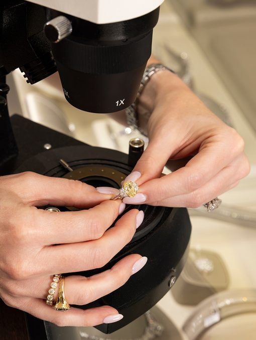 A Perry’s gemologist examining a yellow diamond under the microscope