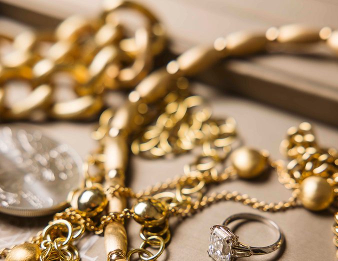Gold chains and a diamond ring on a jeweler’s tray