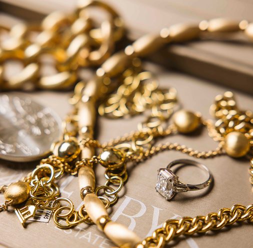Gold chains and a diamond ring on a jeweler’s tray