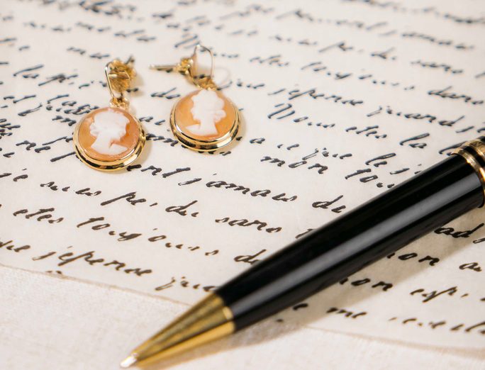 Cameo drop earrings on a handwritten letter